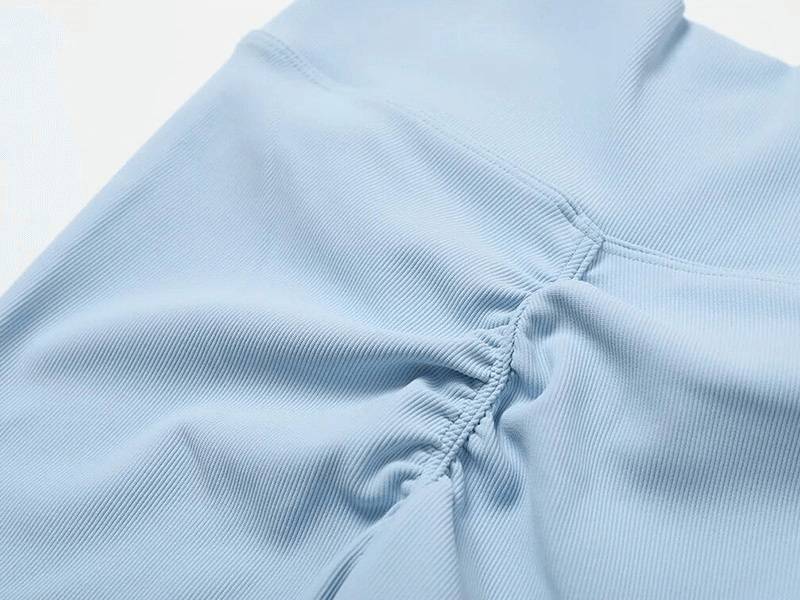 Close-up of blue seamless sports leggings showing ruched detail, part of Fashion Female 2pcs Set SF1717, made with breathable fabric.