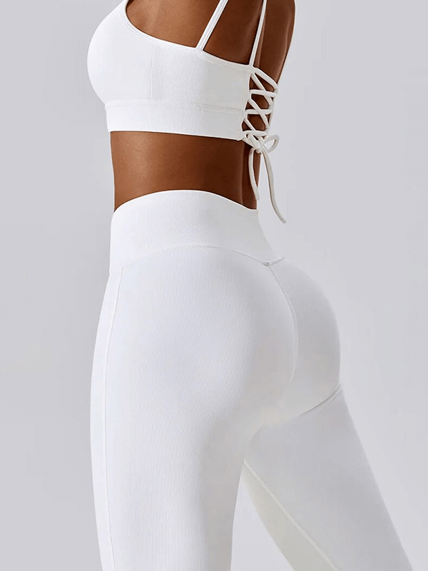 Woman wearing white seamless sports set with strappy back, ideal for fitness and active lifestyle.