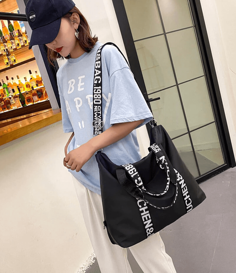 Woman with black fashion yoga handbag, styled with unique straps, ideal for travel and fitness. Casual and chic ensemble.