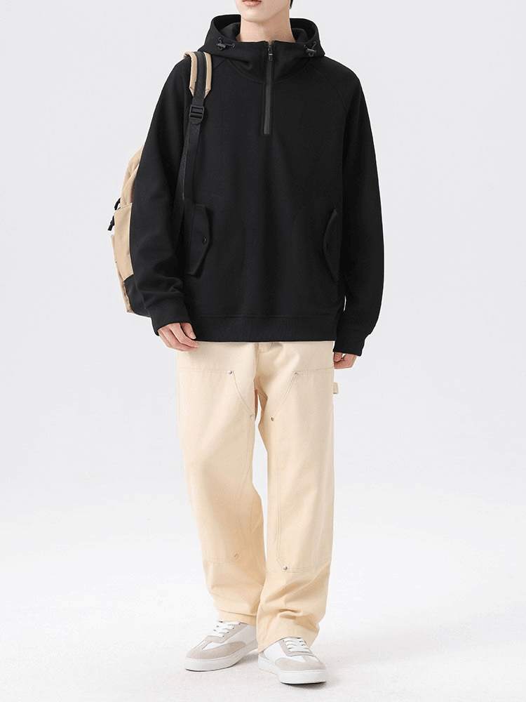 Model wears black fashion long sleeves half-zip hoodie with pockets and beige pants, showcasing casual style and comfort.