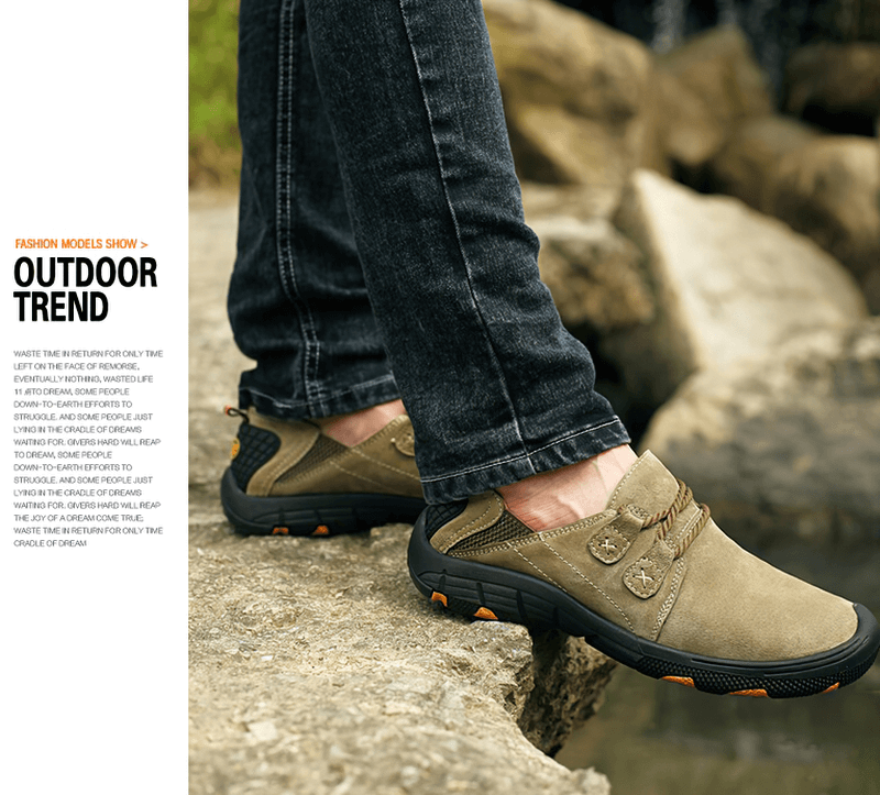 Man wearing Fashion Male Breathable Genuine Leather Shoes for outdoor trekking on rocky terrain, showcasing comfort and style.