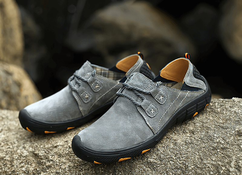 Fashionable male breathable leather trekking shoes SF1344 on rocky surface, featuring cow leather and rubber outsole for outdoor adventures.