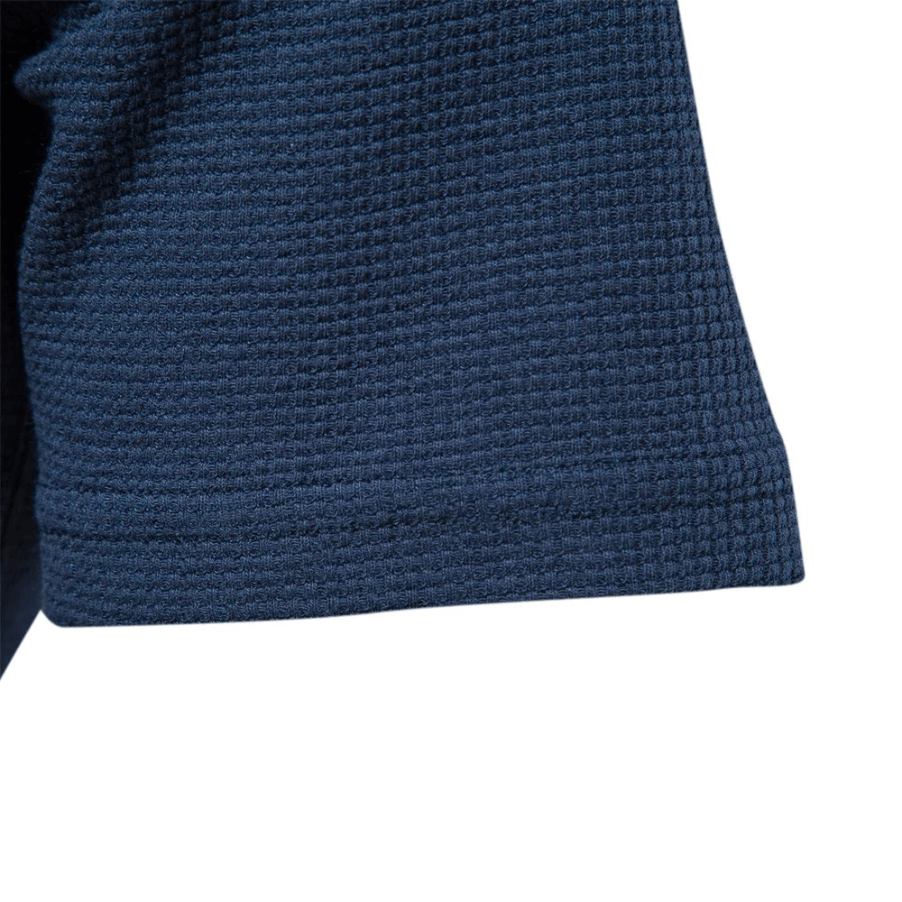 Close-up of navy waffle texture short sleeve on men's solid color t-shirt, highlighting fabric detail.