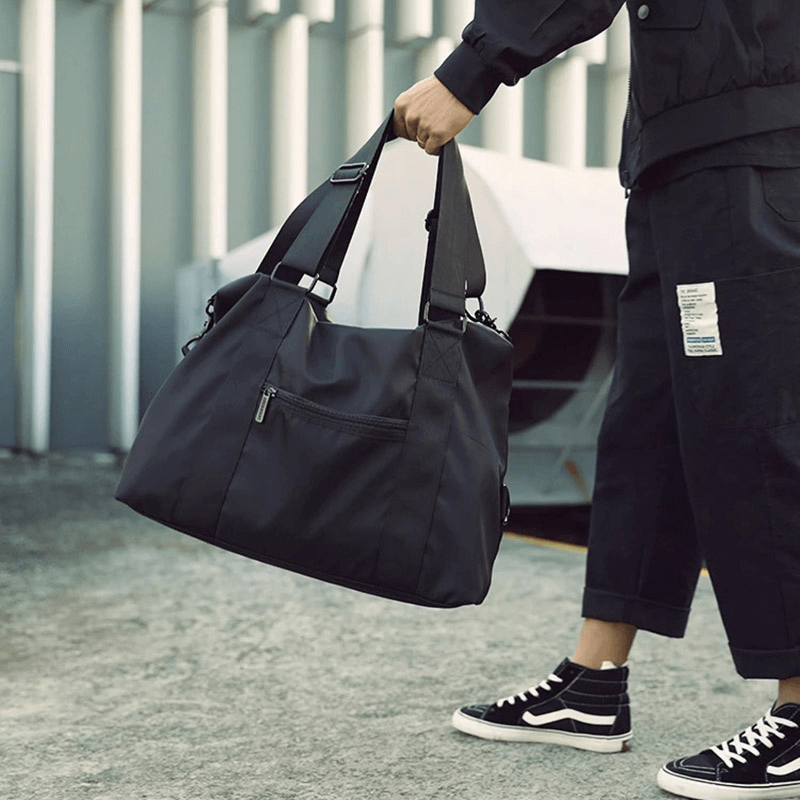 Stylish black nylon crossbody travel bag SF1959 with 20-35L capacity, ideal for outdoor fitness and adventures, held by a male model.