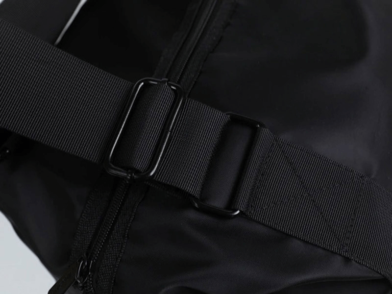 Close-up of durable black nylon crossbody shoulder bag strap with zipper closure, ideal for travel and fitness, capacity 20-35L.
