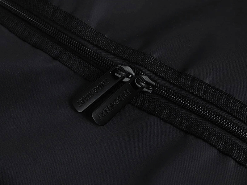 Close-up of black nylon travel bag with zipper closure, showcasing durable material and sleek design for outdoor activities.
