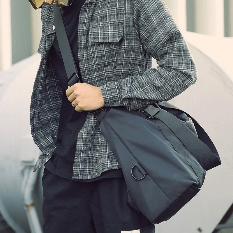 Man wearing plaid shirt carrying black nylon crossbody travel bag, perfect for fitness and outdoor activities, SF1959 model.