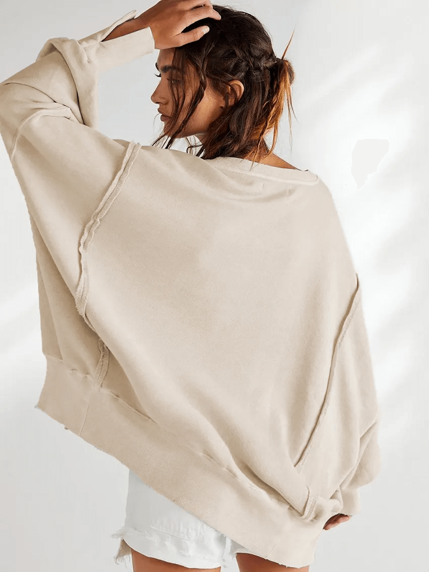 Woman modeling a beige drop shoulder loose sweatshirt with three-quarter sleeves, perfect for a casual look. Fashion solid color, O-neck style.
