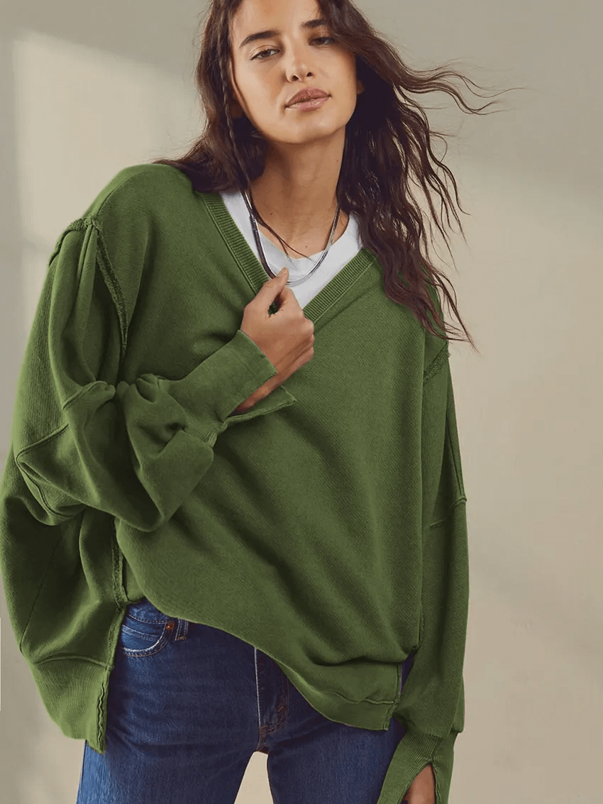 Woman wearing a green drop shoulder loose sweatshirt, casual style, perfect for a chic look. Fashionable O-neck and three-quarter sleeve.