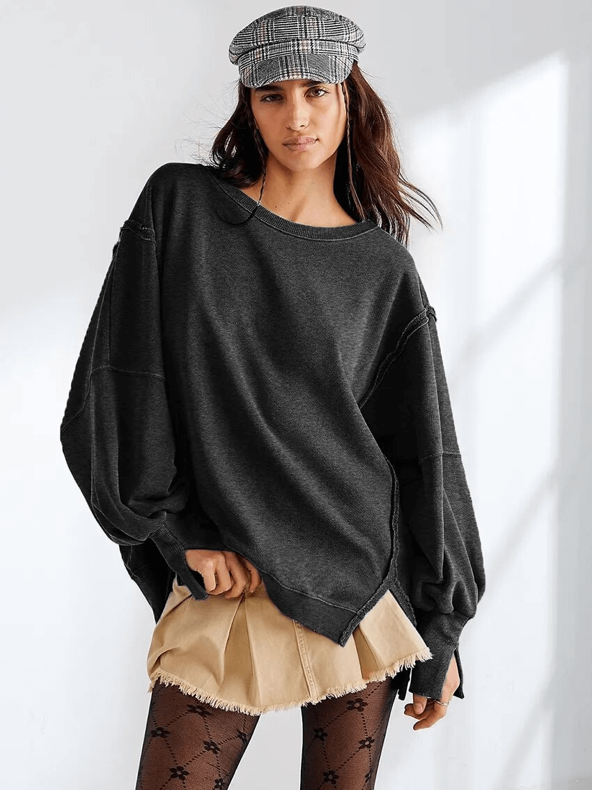 Woman wearing a solid color drop shoulder loose sweatshirt SF1582, styled casually with a cap, highlighting O-Neck and non-stretch fit.