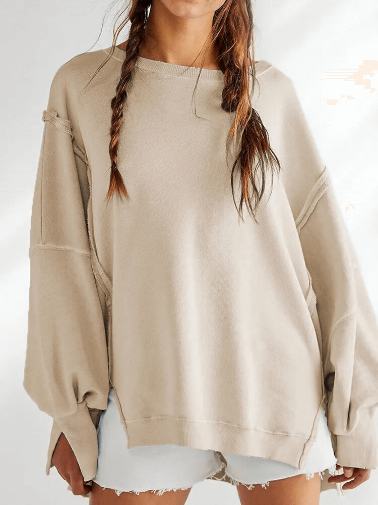 Woman wearing a beige solid color drop shoulder loose sweatshirt with an O-neck collar and three-quarter sleeves, ideal for casual wear.