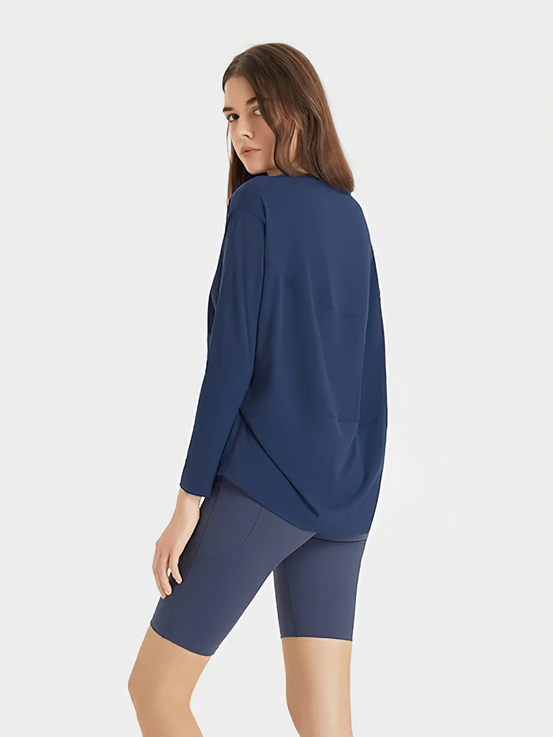 Woman wearing a navy blue fashion solid color long sleeves loose top for gym, ideal for workouts, made of nylon and spandex blend.