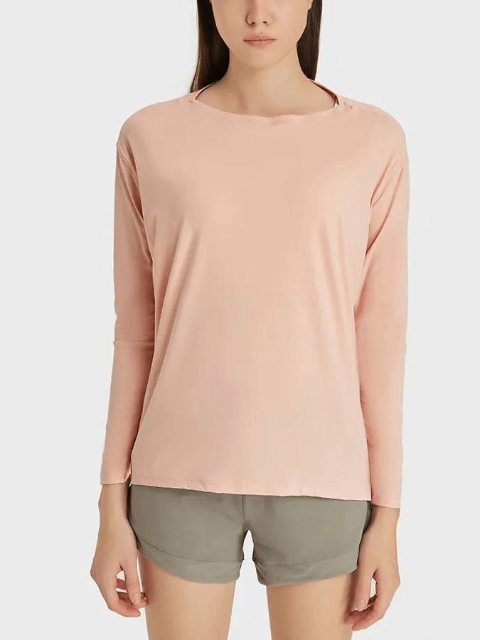 Woman wearing a solid color long sleeves loose top, perfect for gym workouts, durable and comfortable in pink, model SF1821