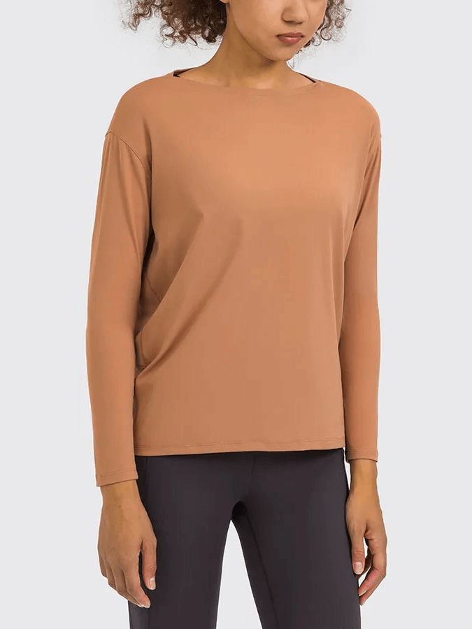Woman wearing a solid brown long-sleeve gym top, ideal for workouts, made from durable nylon-spandex blend for comfort and durability.