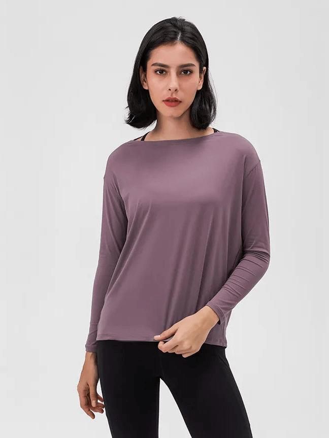 Woman wearing a solid color long sleeves gym top, highlighting durability and comfort in breathable, quick-drying fabric, model SF1821.