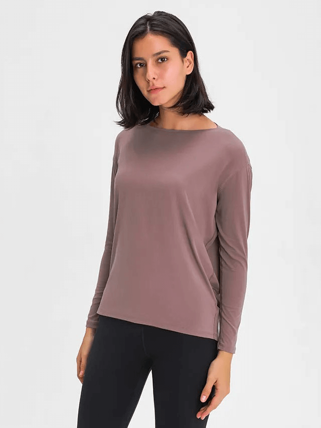 Woman wearing fashion solid color long sleeves loose gym top SF1821 in breathable broadcloth fabric, ideal for active wear.