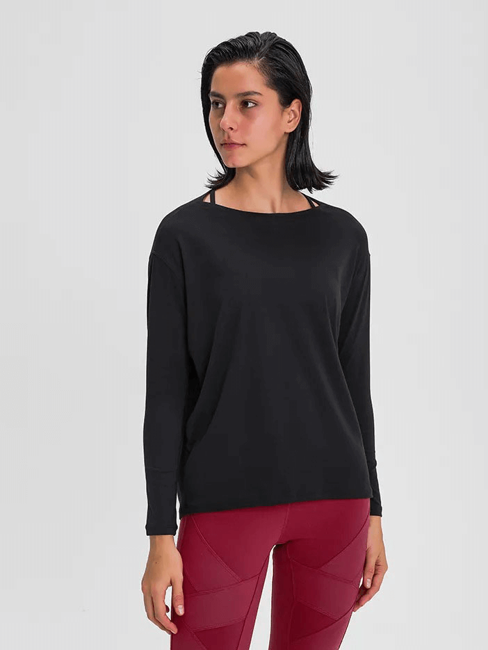 Woman wearing black long sleeves loose gym top SF1821 over red leggings, perfect for workouts.