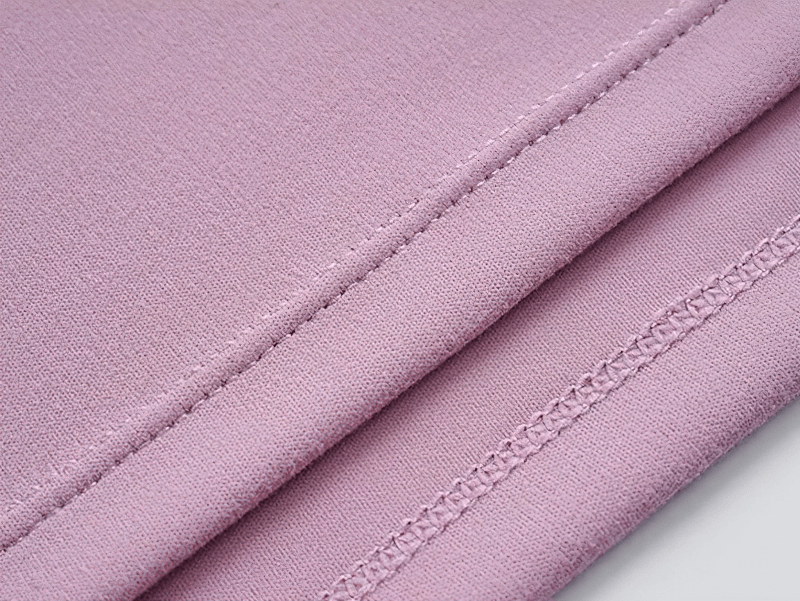 Close-up of pink fabric and stitching on gym top, showcasing quality and durability of solid color long sleeves loose top for workout.