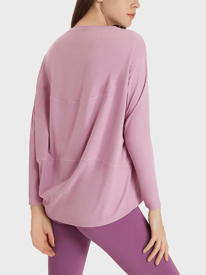 Woman wearing purple loose long sleeves top for gym from back view.
