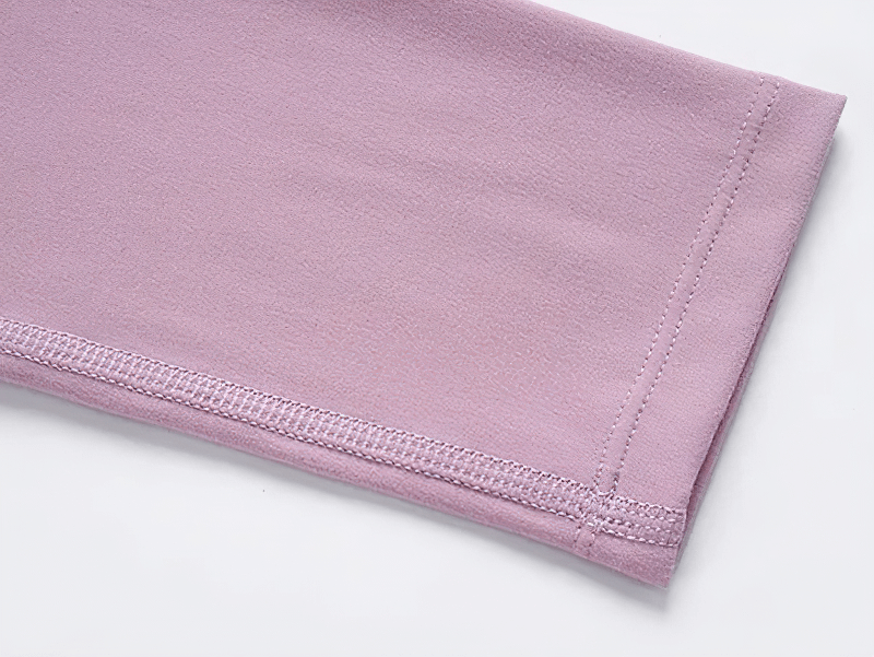 Close-up of pink gym top sleeve showcasing fabric texture and stitching detail.