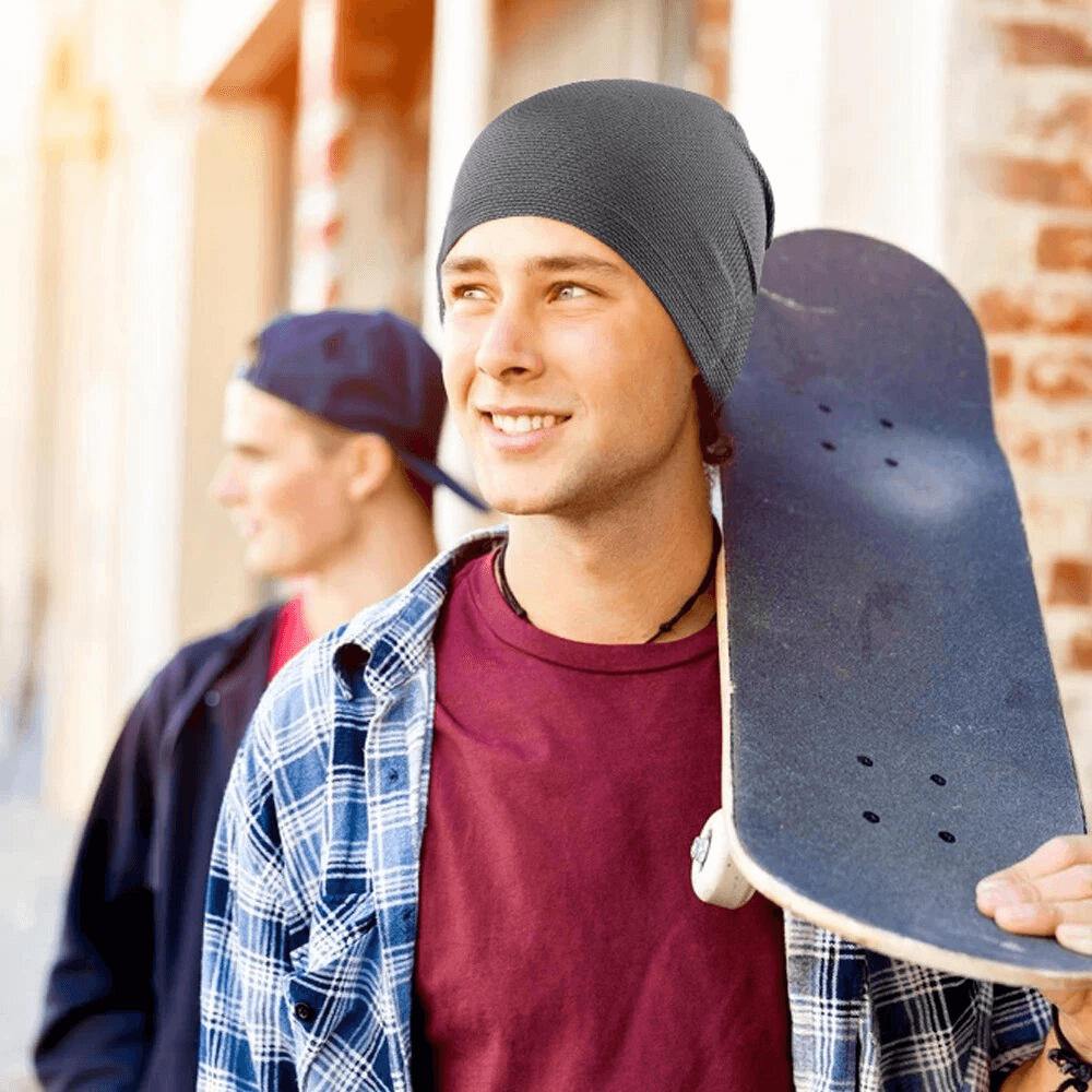 Young man wearing a Fashion Thin Breathable Beanie SF1644 with skateboard, outdoor sports style.