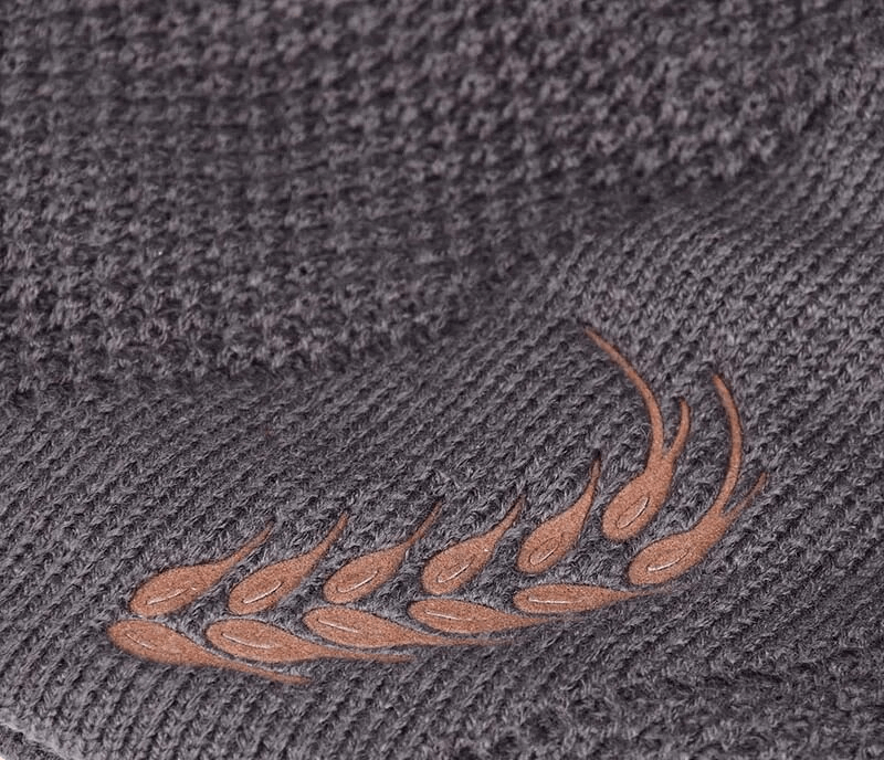 Close-up of a gray knitted ski beanie with a stylish wheat ear pattern in polyester for outdoor adventures.