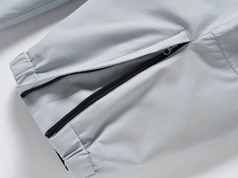 Close-up of light gray windproof and waterproof snowboarding pants with a zipper fly for unisex fashion.