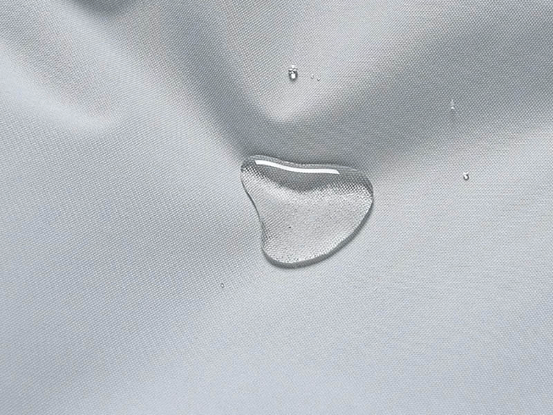 Close-up of water droplet on waterproof snowboarding pant fabric SF1842, showcasing its water-resistant polyester material.