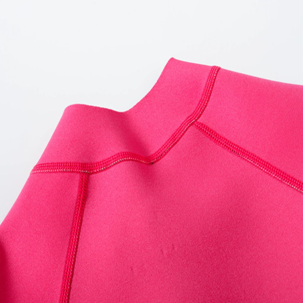 Close-up of bright pink women's rashguard for deep-diving surfing, showcasing durable microfiber stitching, perfect for aquatic adventures.