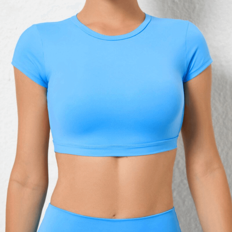 Fashionable elastic cropped blue top with open back, perfect for yoga. Short sleeves, durable nylon, breathable and quick-drying.