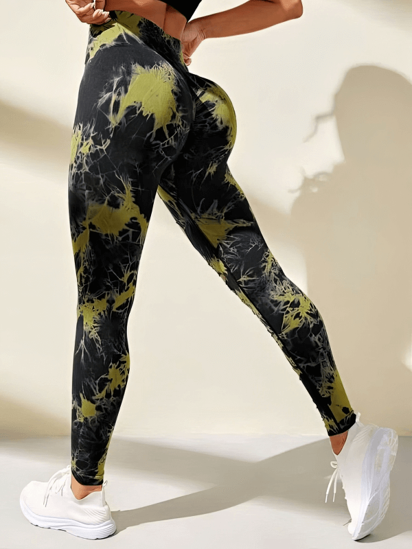 Woman wearing fashionable elastic tight women's leggings with stylish cutouts in black and yellow pattern, ankle-length high-waisted fit.