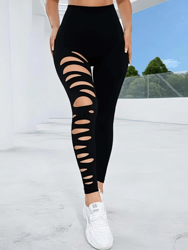 Woman wearing fashionable black leggings with stylish cutouts, high-waisted fit, and ankle-length design for active wear.