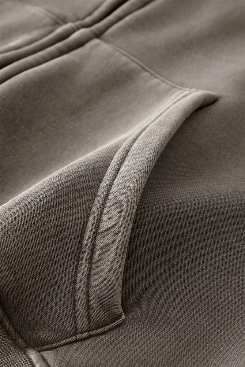 Close-up of fashionable fleece hoodie fabric and pocket detail, showcasing cozy material and craftsmanship.