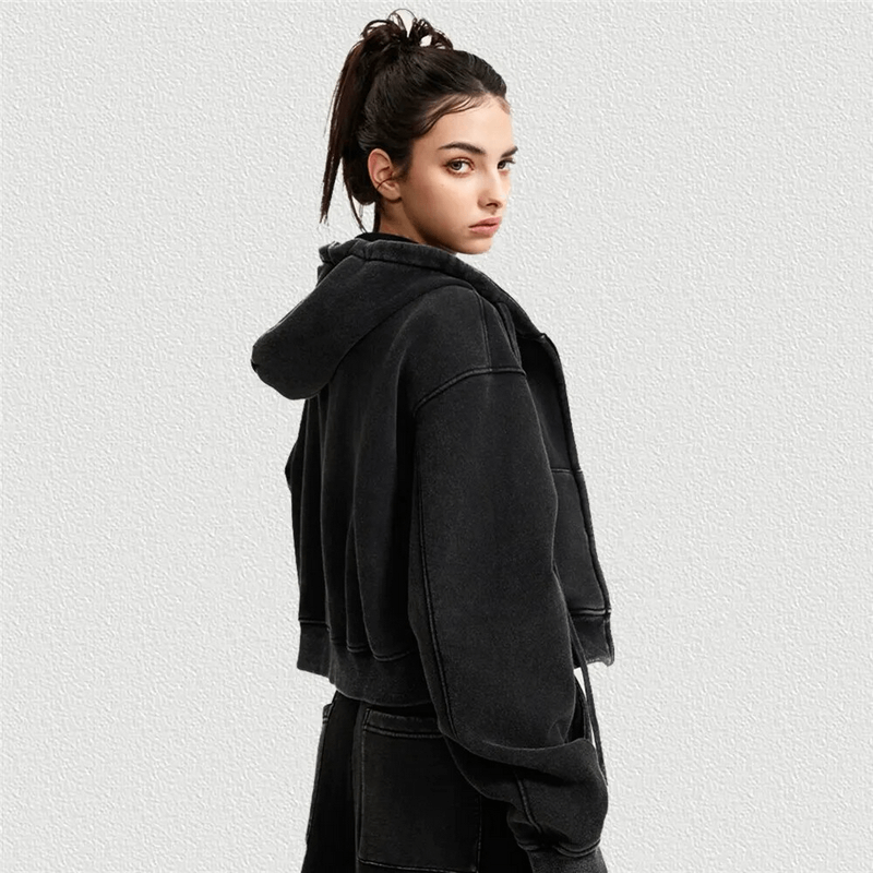Woman models a fashionable fleece short hoodie with distressed details and zipper, ideal for stylish comfort. Perfect for breezy outings.