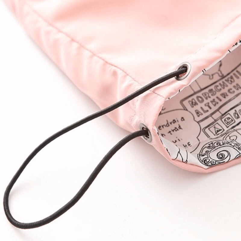 Close-up of pink drawstring and patterned interior of women's windbreaker hood, showcasing design details and craftsmanship.
