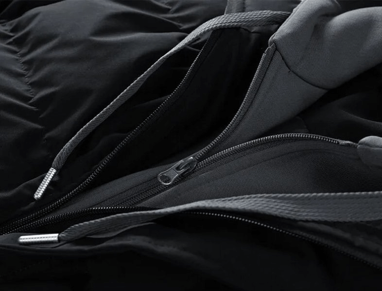 Close-up of zipper and hooded collar on a stylish unisex down jacket, featuring durable cotton filling and polyester lining for warmth.