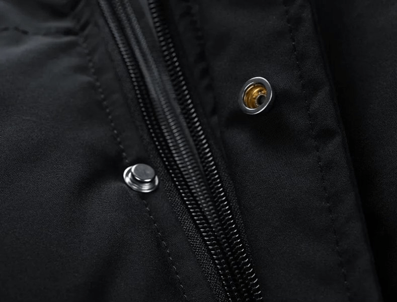 Close-up of black hooded down jacket with zipper and button details, highlighting fashionable winter design.