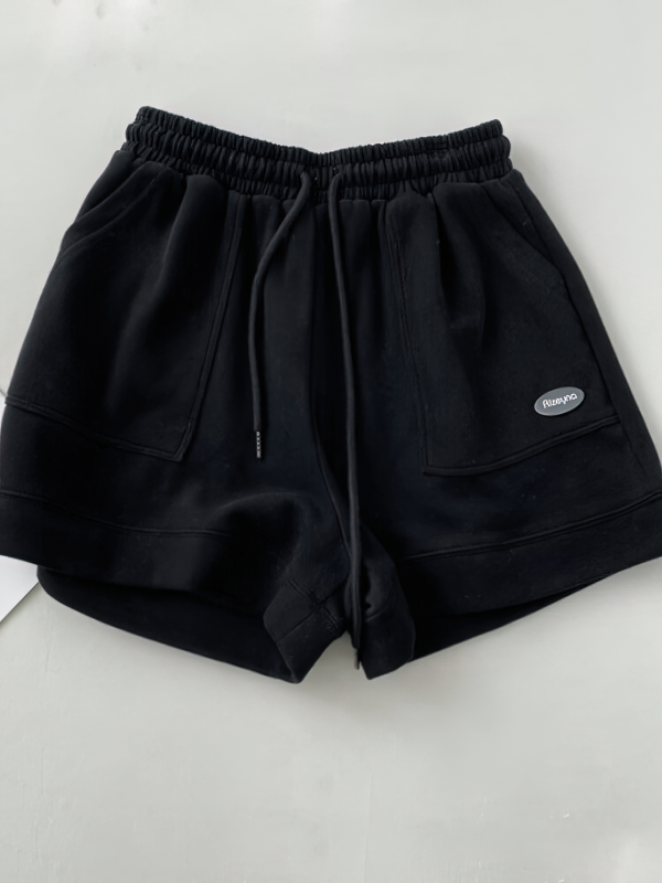 Black fashionable wide women's shorts with large side pockets and drawstring, perfect for casual comfort and style.