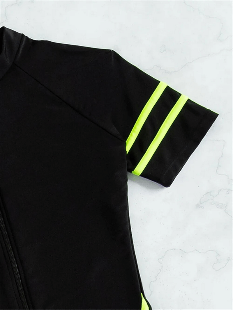 Close-up of black women's swimsuit with neon green striped sleeve and front zipper, spandex fabric, featuring sporty design.