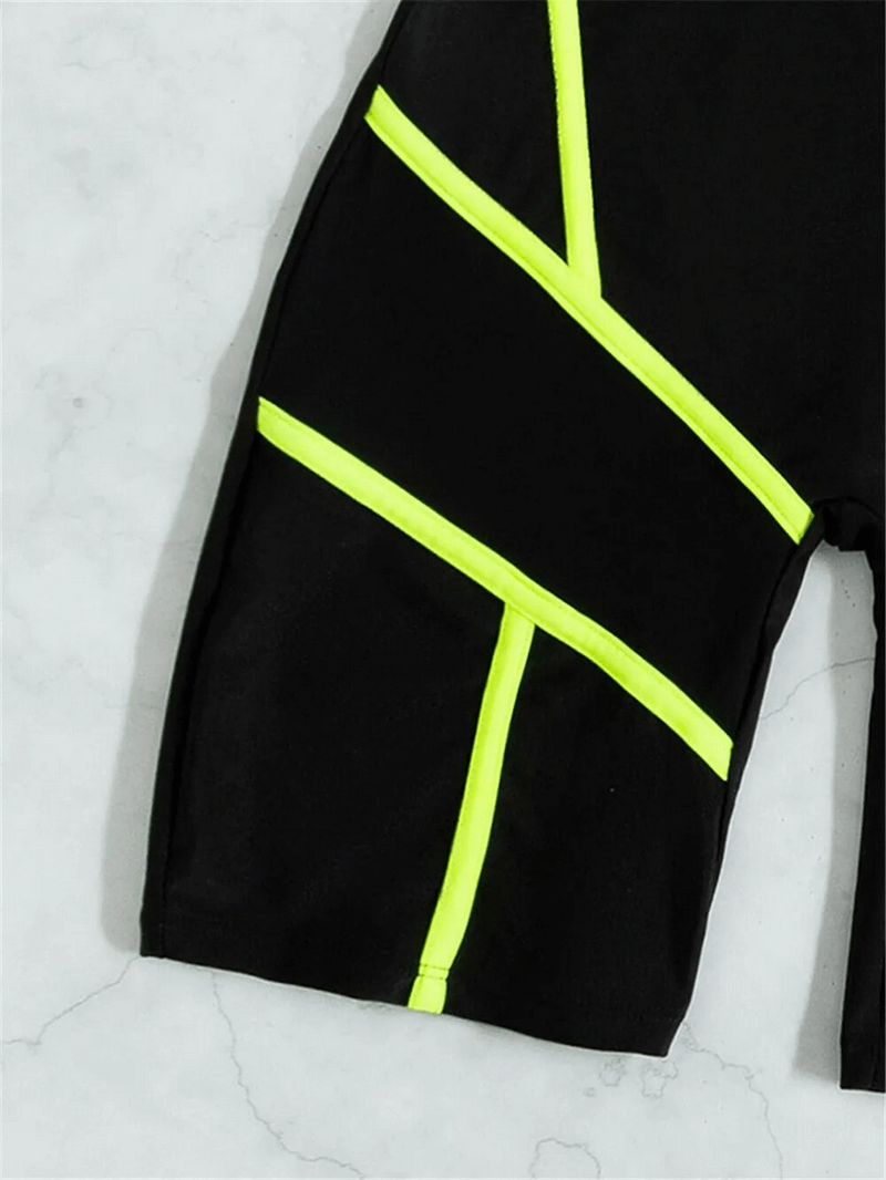 Close-up of black one-piece swimsuit with neon yellow trim, featuring sporty design and mesh detailing - perfect for beach days.