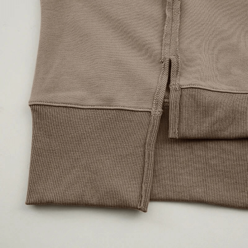 Close-up of beige oversize sweatshirt with reversible seam detail and ribbed cuff, highlighting the comfortable cotton material.