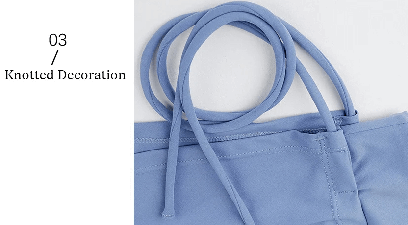 Blue garment with knotted decoration detail showcasing elegant fashion design.