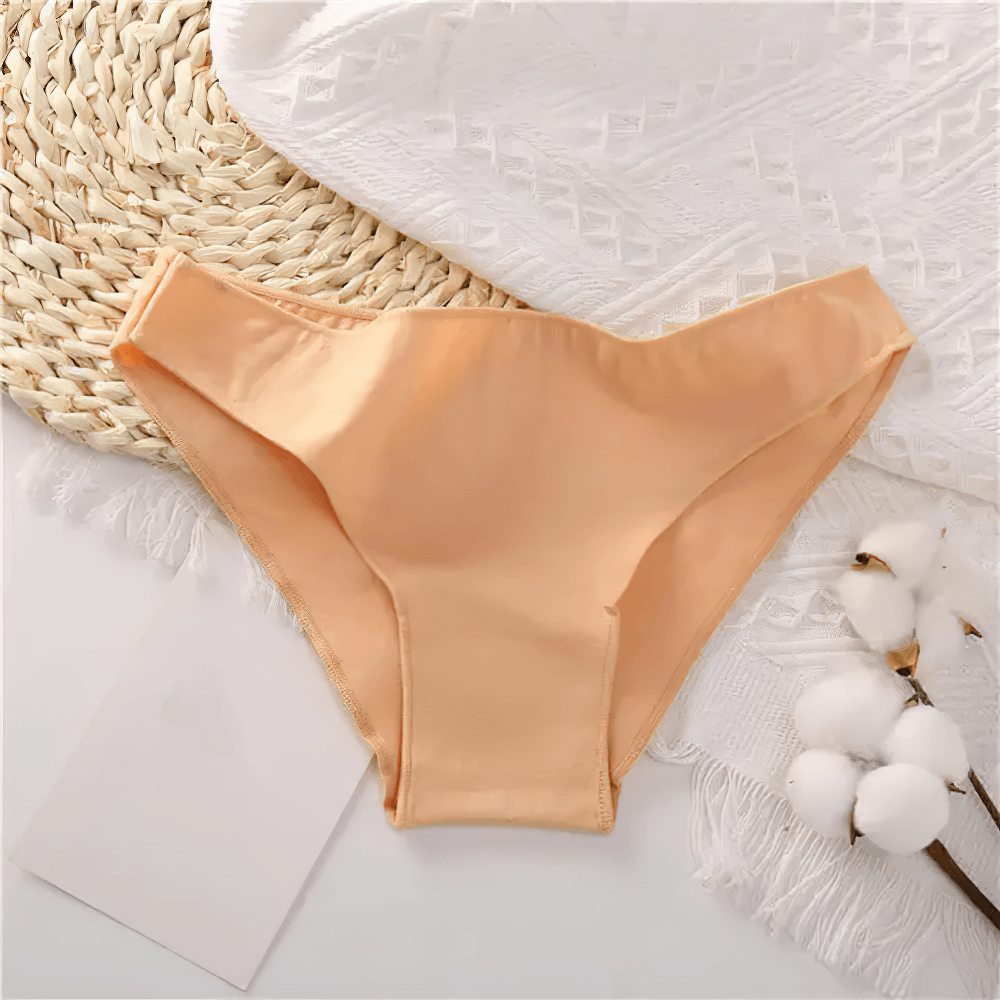 Female Low Waist Cotton Panties with Smooth Edges - SF4667 in soft peach color laid on a woven surface.