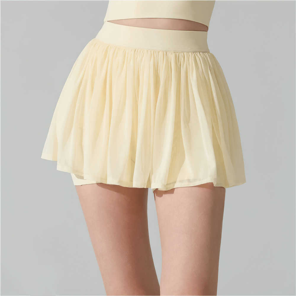 Female Pleated Tennis Skort with Built In Shorts - SF4577 in a soft yellow color, showcasing pleats and built-in shorts.