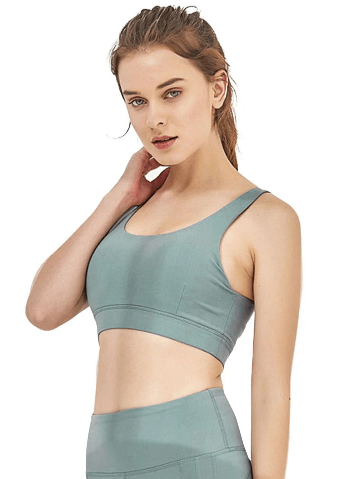 Woman wearing a sexy backless nylon sports bra for gym workouts.