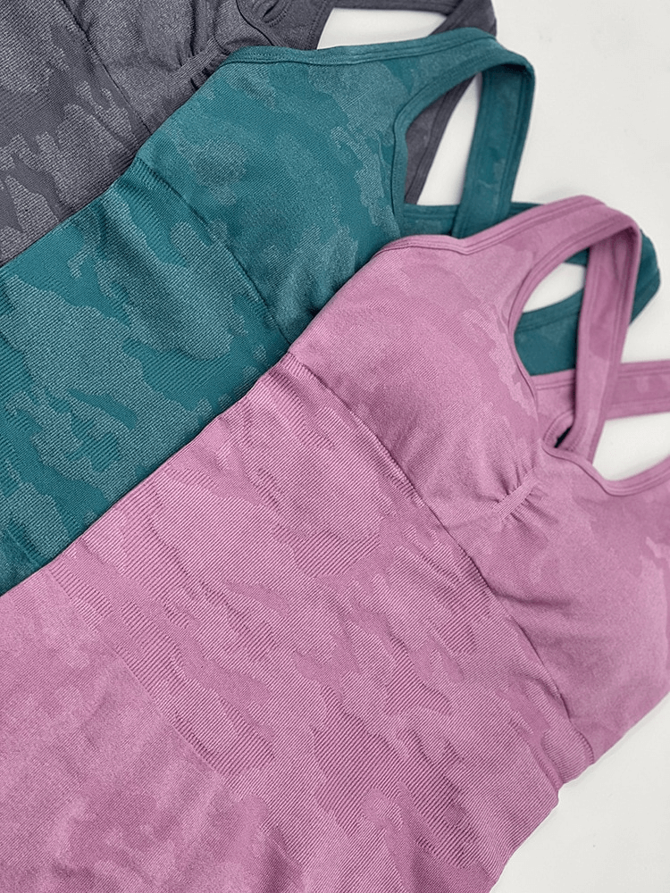 Three seamless sleeveless jumpsuits in pink, teal, and grey, perfect for yoga and workouts, featuring quick-drying fabric and modern design.