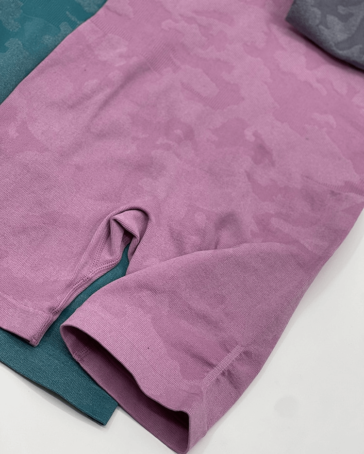 Female sleeveless seamless jumpsuit in pink and green, perfect for yoga or sports, showing breathable fabric and sleek design.