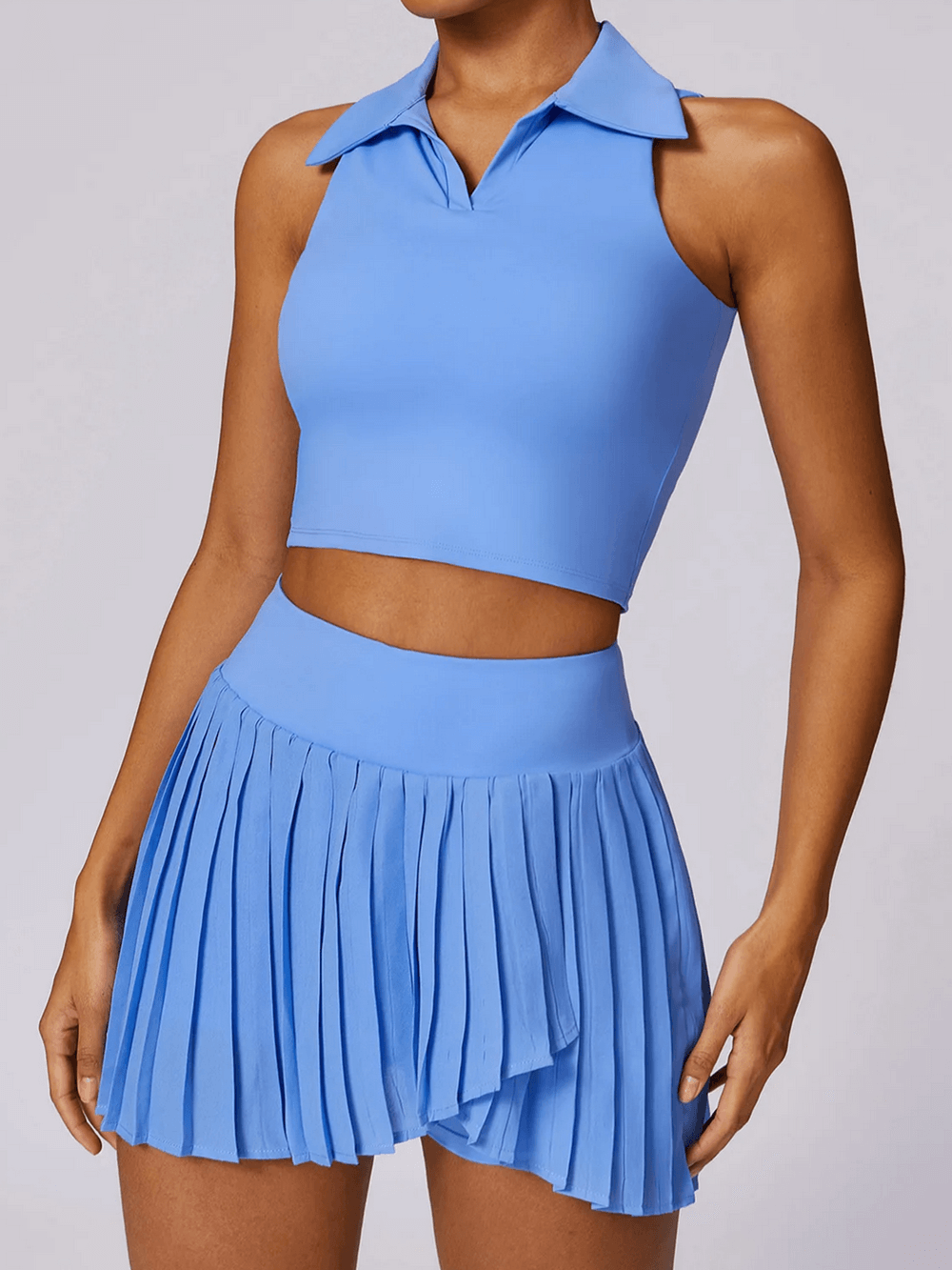 Stylish blue sleeveless tank and pleated sports skirt set for women, ideal for yoga, running, and fitness, with quick-dry fabric.