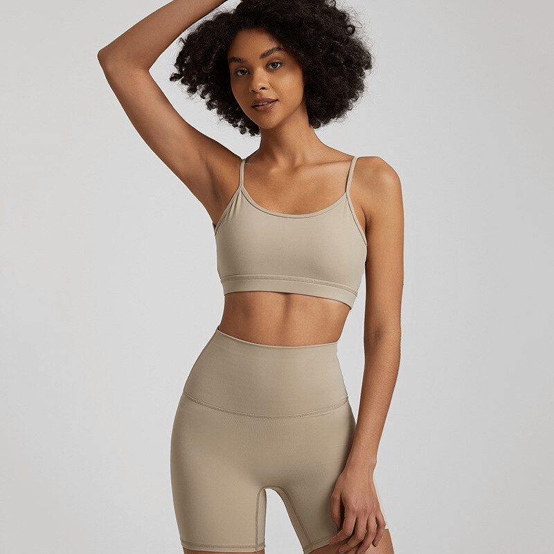Model wearing female solid color open back sports bra and shorts, showcasing activewear fit for workouts. SF1488. Quick-dry, breathable fabric.