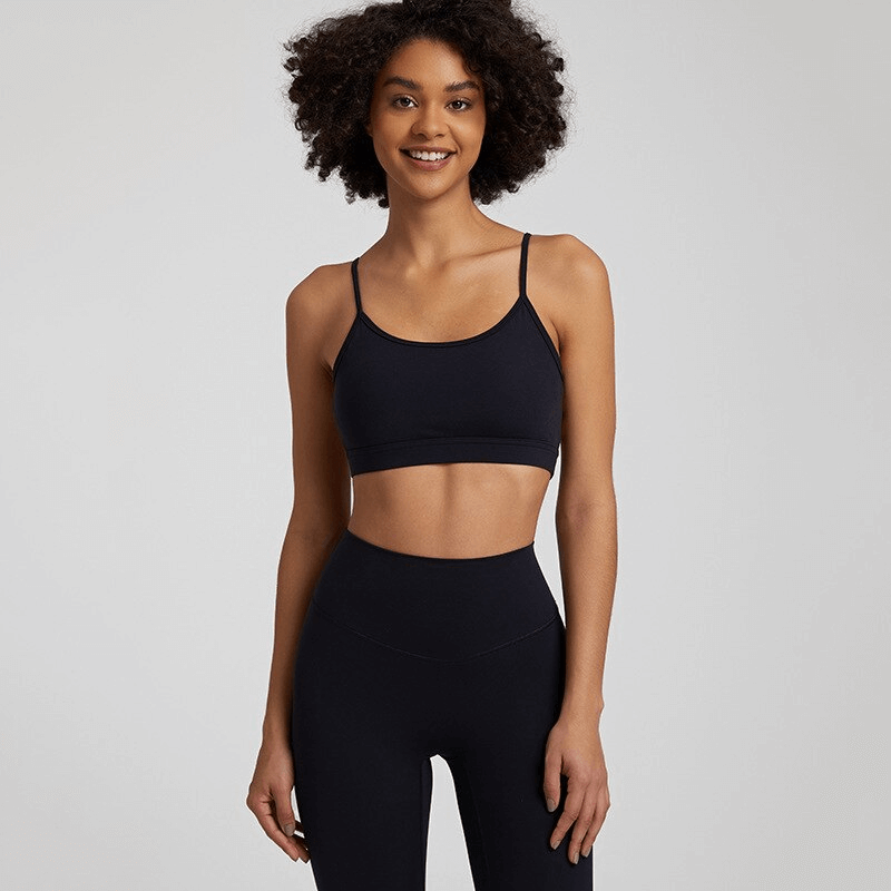 Woman wearing a black solid color open back sports bra and matching leggings, SF1488 activewear, ideal for workouts and active lifestyle.